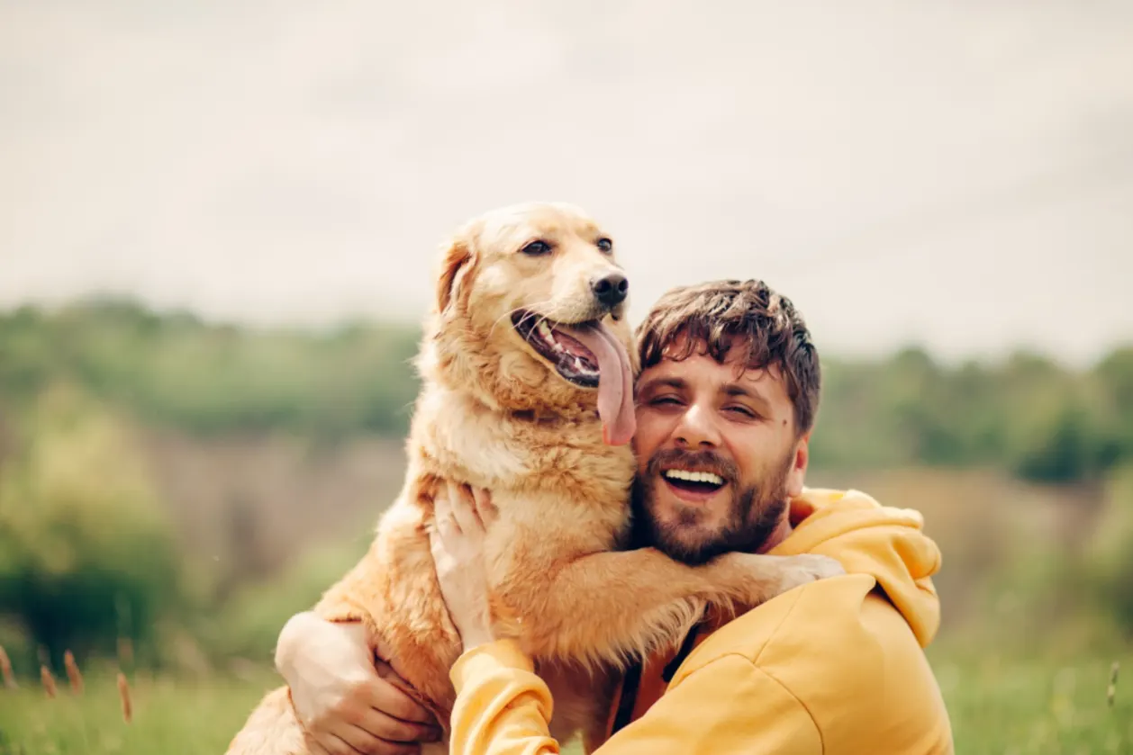 man and his golden retriever in nature